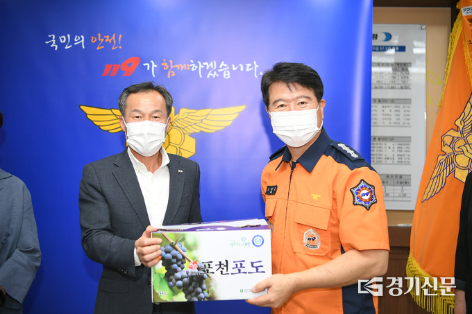 포천시의회 서과석 의장(왼쪽)이 포천소방서 조창근 서장에게 위문품으로 준비한 포천포도를 증정하고 있다. (사진=포천시의회 제공)
