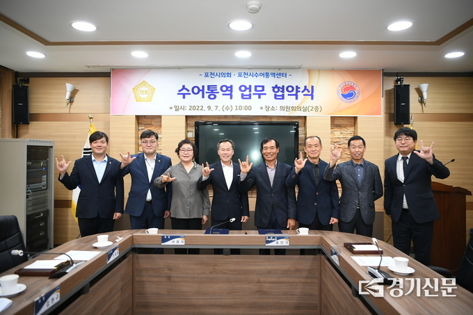 협약식 참석자들이 오른손으로 '사랑해요'라는 뜻의 수어를 즉석에서 배월 해 보이고 있다. (사진=포천시의회 제공)