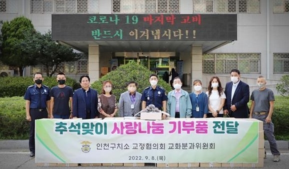 인천구치소 교정협의회 관계자들이 수용자들에게 추석 기부품 전달한 뒤 사진촬영을 하고 있다. ( 사진 = 인천구치소 제공 )
