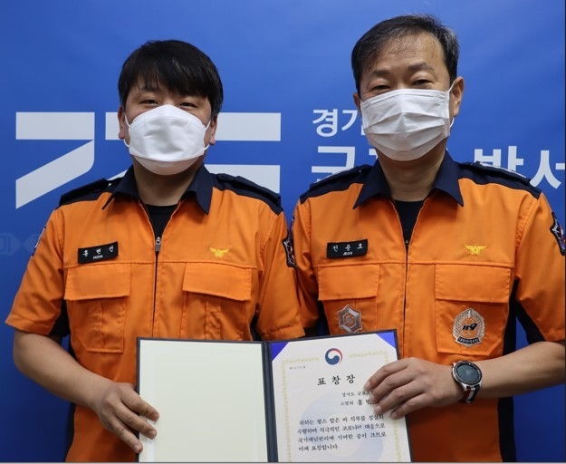 코로나19 대응 유공자로 119구급대장 소방위 홍변선(왼쪽)이 소방청장 표창을 수상했다. (사진=군포소방서 제공)