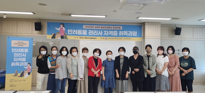 화성시여성비전센터 관계자들이 4060세대를 대상으로 실시한 '반려동물 관리사 자격증 취득과정'을 마친 수강생들과 함께 기념촬영을 하고 있다.(사진=화성시여성비전센터 제공)