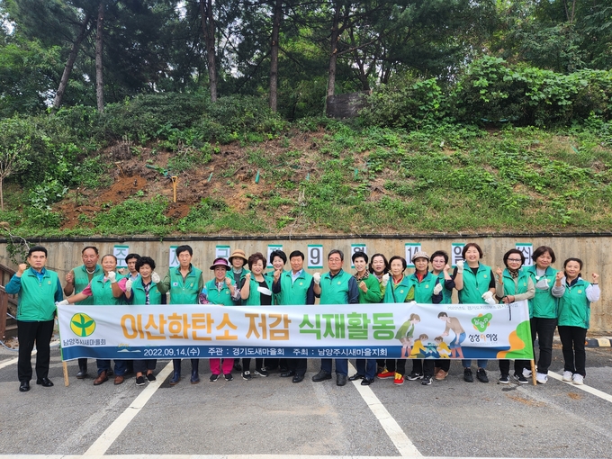 남양주시새마을회는 14일 마을공동회관 인근 산지에서 이산화탄소 저감을 위해 사랑의 나무심기를 하고 기념촬영을 했다.(사진=남양주시 제공)