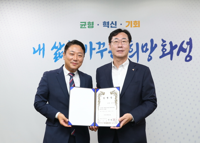  진석범 신임 화성시사회복지재단 대표이사( 왼쪽)가 정명근 이사장으로부터 임명장을 받고 있다.다.(사진=화성시 제공)