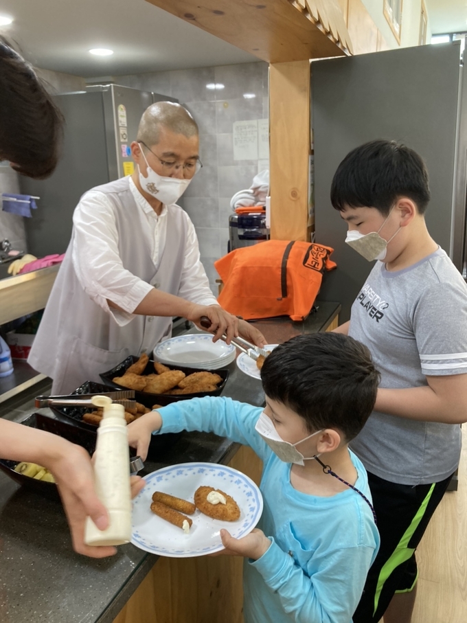초등학생들에게 아침밥을 전하는 원돈스님.(사진=시흥시 제공)