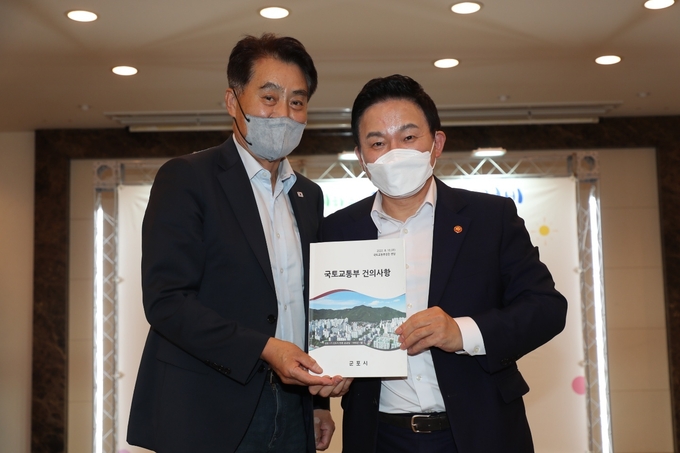 하은호 군포시장(왼쪽)이 원희룡 장관에게 건의서를 전달하고 있다.(사진=군포시 제공)
