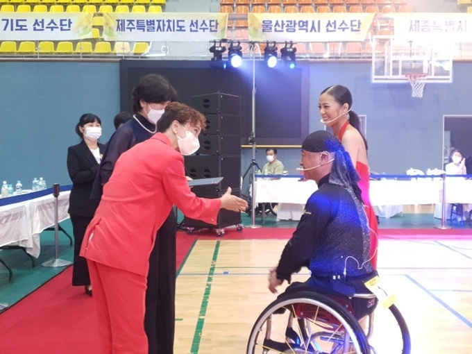 지난 17일 성남종합스포츠센터 다목적체육관에서 열린 2022 경기도지사배 전국장애인댄스스포츠선수권대회 개회식에서 참가선수단을 대표해 문진호-박미주 선수가 선수대표 선서를 한 뒤 유채옥 대한장애인댄스스포츠연맹 회장, 조아라 경기도장애인댄스스포츠연맹 회장과 악수를 하고 있다. (사진=경기도장애인체육회 제공)