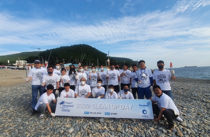 지난 23일 부산시 영도구 감지해변에서 진행된 ‘국제 해안 클린업데이’ 행사에서 동원산업 직원들이 기념 사진 촬영을 하고 있다. (사진=동원그룹 제공)