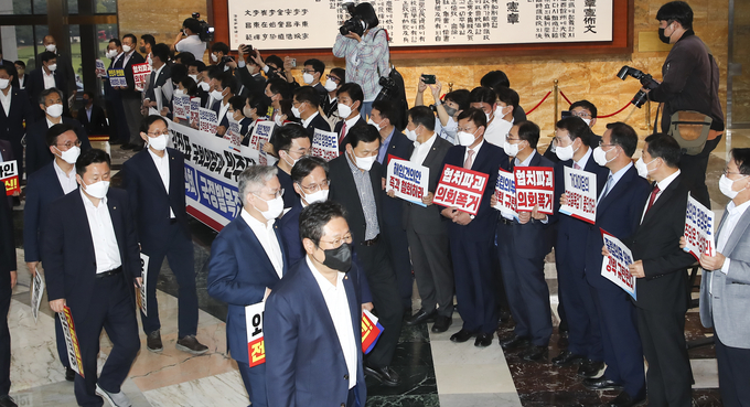 29일 국회 로텐더홀에서 박진 외교부장관 해임 건의안 상정에 항의하는 국민의힘 의원들 앞으로 더불어민주당 의원들이 본회의장으로 입장하고 있다. (사진=연합뉴스/국회사진기자단 제공)