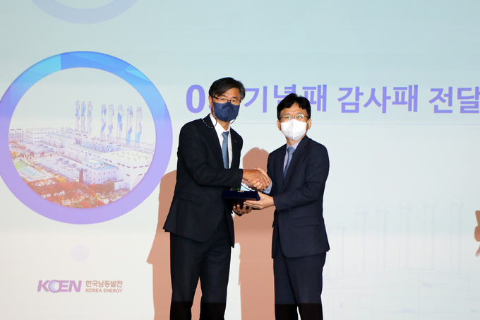  지난달 29일 한국남동발전 분당발전본부에서 개최된 가스터빈 핵심부품 국산화 개발 기념식에서 이상규 한국남동발전 안전기술부사장(사진 왼쪽)과 우타관 성일터빈 대표가 감사패와 기념패를 서로 전달하고 있다.