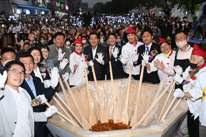  이재준 수원시장이 지난달 30일 수원 통닭거리에서 열린 ‘2022 수원 통닭거리 축제, 통닭에 빠지다’ 개막식에서 상인들과 함께 ‘닭강정 비빔 퍼포먼스’를 하고 있다. (사진=수원시 제공)