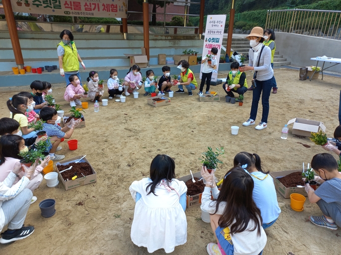 군포 능내초와 도장초 학생들이 수릿길 식물심기 체험활동을 벌이고 있다.(사진=군포시 수리동 주민자치회 제공)