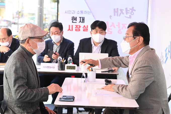 이현재 시장이 시민들의 생활 불편해소와 각종 민원 해결을 위해 이동시장실을 마련하고 한시민의 민원을 경철하며 이야기를 나누고 있다.(사진=하남시 제공)
