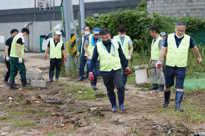 지난 8월 13일 용인시의회 의원들이 고기동 수해현장에서 구슬땀을 흘리고 있다.(사진=용인시의회 제공)