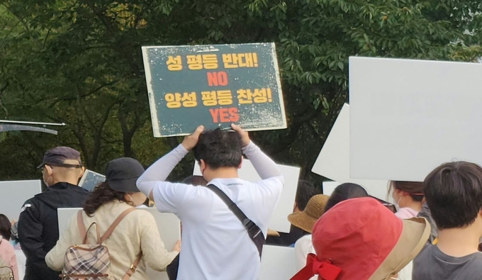 15일 인천 남동구 구월동 중앙공원 하트분수지구에서 열린 인천시민가족사랑축제에 참가한 참가자가 ‘성 평등 반대! NO 양성 평등 찬성! YES' 손팻말을 들고 있다. ( 사진 = 박지현 기자 )