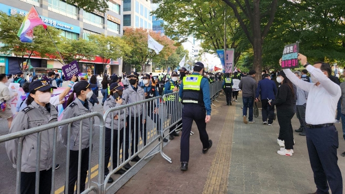 15일 인천 남동구 구월동 중앙공원 일대에서 경찰들을 사이에 두고 거리행진을 하는 퀴어축제 참가자들과 퀴어축제 반대집회 참가자들이 서로를 향해 ‘성소수자 부모모임’ 손팻말과 ‘동성결혼·동성애법제화 결사반대’ 손팻말을 보이고 있다. ( 사진 = 박지현 기자 )
