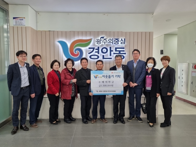 김중기 동해시 발한동장등 주민자치위원회회원들이 표동진 경안동장에게 수해 의연금 전달하고 기념하고 있다.(사진=광주시 제공)