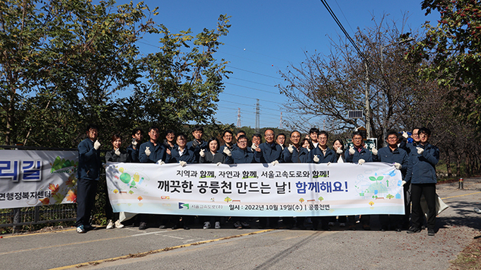 유인준 서울고속도로대표와 직원들이 본사 인근 공릉천에서 환경정화 활동에 앞서 기념사진을 찍고 있다.(사진=서울고속도로 제공)