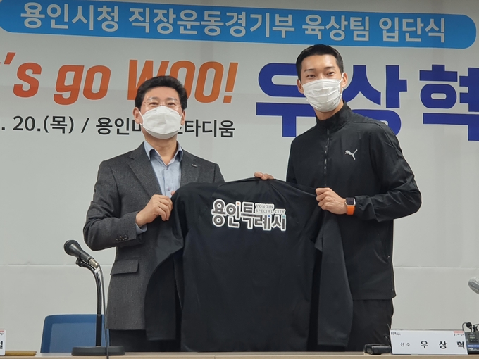 우상혁(오른쪽)이 20일 용인 미르스타디움에서 열린 '용인시청 직장운동경기부 육상팀 입단식'에서 이상일 용인시장에게 단복을 받은 뒤, 기념 촬영하고 있다. (사진=연합뉴스)
