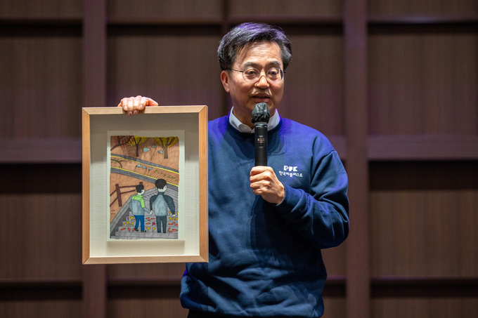 김동연 경기도지사가 발달장애인 황진호 작가로부터 구입한 아빠와 함께라는 작품을 소개하고 있다. (사진=경기도 제공)