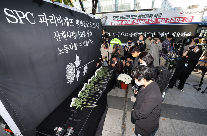 20일 SPC 본사 앞에서 열린 사망 사고 희생자 추모행사에서 참가자들이 헌화하고 있다. (사진=연합뉴스)