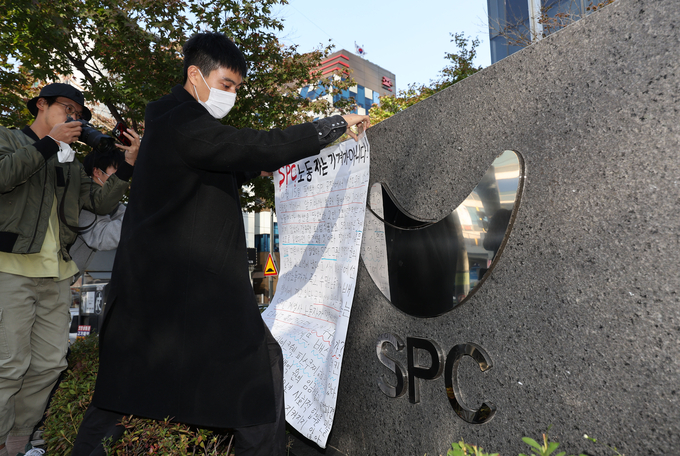  20일 오후 서울 양재동 SPC 본사 앞에서 열린 평택 SPC 계열사 SPL의 제빵공장 사망 사고 희생자 서울 추모행사에서 성공회대 노학연대모임 가시 관계자가 대자보를 붙이고 있다. (사진=연합뉴스)