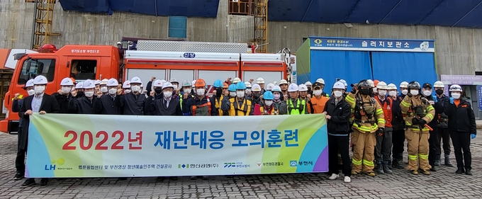 26일 ‘웹툰융합센터·청년예술인 주택 건설현장’에서 한국토지주택공사 계양부천사업본부, 부천시 365안전센터, 부천소방서 119안전센터, 원미경찰서 관계자들이 재난대응 모의훈련을 한 뒤 기념촬영을 하고 있다. ( 사진 = 계양부천사업본부 제공 )
