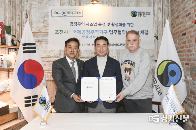 국제공정무역기구 한국사무소 지동훈 대표(왼쪽), 장자크 그로하 공동대표(오른쪽)와 백영현 포천시장(가운데)이 협약서를 들어보이고 있다. (사진=포천시 제공)