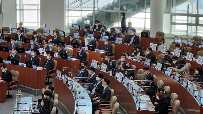 경기도의회 민주당 의원들은 ‘국민의힘은 민생추경 동참하라’ ‘지역상권 다 죽는다 민생추경 동참하라’ 등 내용이 적힌 피켓을 좌석에 붙인 채 본회의에 참석했다. (사진=허수빈 기자)