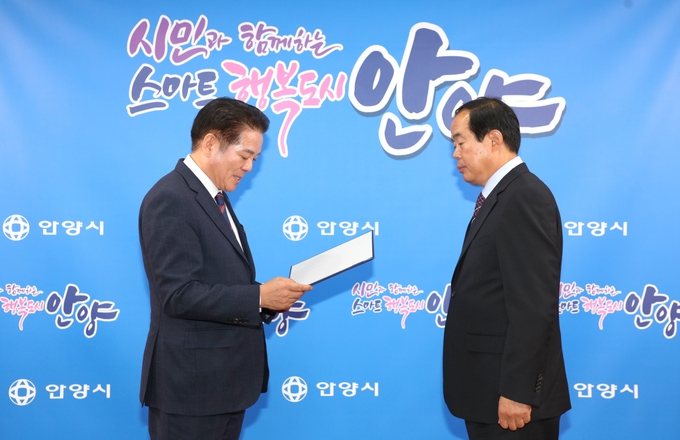 최대호 안양시장(왼쪽)이 권주홍 민원옴부즈만에게 위촉장을 수여하고 있다.(사진=안양시 제공)