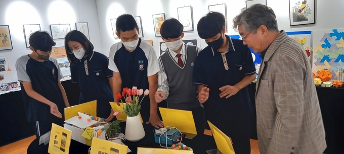  예술공감터 전시 작품들을 감상하는 최민규 교장과 학생들. (사진=부천중흥중학교 제공)