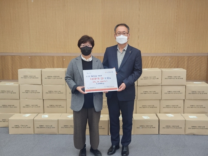 농협은행 가평군지부 이유섭 지부장이 양순분 가평군 장애인복지관장에게 사랑의 쌀을 전달하고 있다.(사진=NH농협은행 가평군지부 제공)