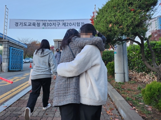 2023학년도 대학수학능력시험이 치러지는 17일 오전 수원 영복여고 앞에서 한 학부모와 자녀가 서로를 포옹하며 격려하고 있다. (사진=강현수 기자) 