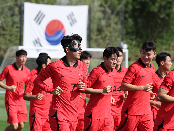  안면보호대를 착용한 '캡틴' 손흥민(왼쪽 두번째) 등 축구 국가대표팀 선수들이 16일 오전(현지시간) 카타르 도하의 알에글라 훈련장에서 진행된 첫 '완전체' 훈련에서 러닝을 하며 몸을 풀고 있다. (사진=연합뉴스)