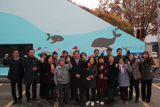 복지관 벽화봉사단원들이 산성제1공영주차장 작품 앞에서 기념촬영을 하고 있다. (사진=수정노인종합복지관 제공)