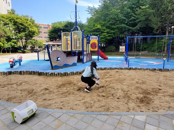 경기도보건환경연구원이 어린이놀이시설 내 모래를 채취하고 있다. (사진=경기도 제공)