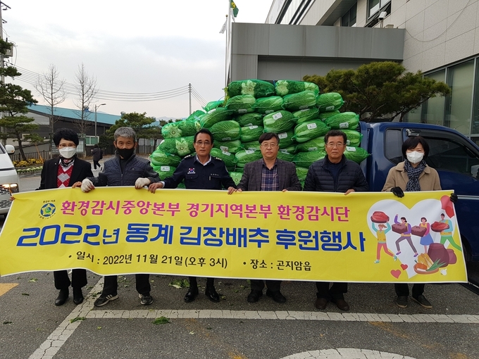 김수복 환경감시중앙본부 경기지역본부장과 단원들이 어려운 이웃을 위해 김장배추 500여포기를 강명원 곤지암읍장에게 전달하고 있다. (사진=광주시 제공)