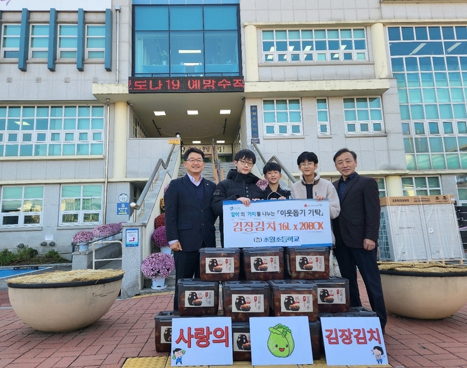 윤현봉 초월초등학교장과 학생들이 교사와 학생들이 직접담은 김장김치를 어려운 이웃에게 전해달라며 구정서 초월읍장에게 전달하고 있다.(사진=광주초월초 제공)
