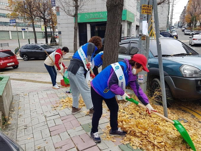 지난 21일 인천 남동구 구월1동 독점로에서 행복복지센터 직원들과 통장협의회 회원들이 함께 낙엽을 정리하고 있다. ( 사진 = 남동구 제공 )