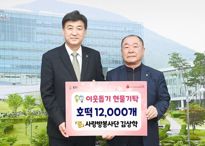 김상학 사랑방봉사단회장이 저소득층에게 나눠 달라며 호떡을 방세환시장에게 전달하고 있다.(사진=광주시 제공)