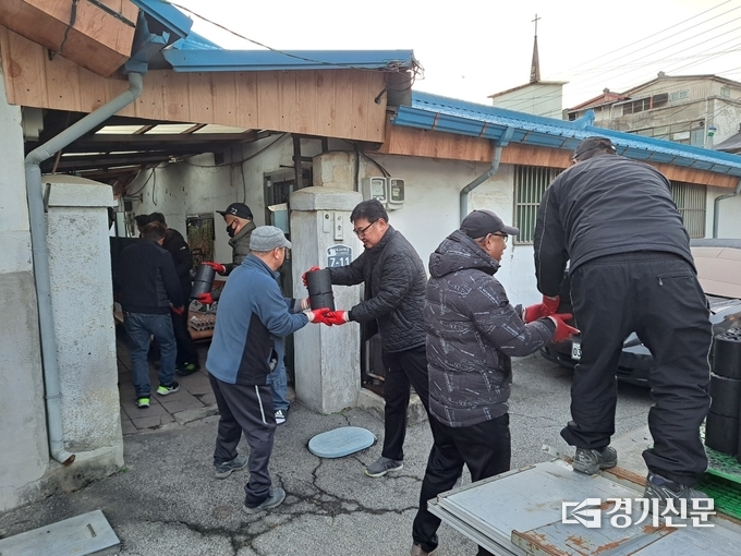영북면청년기수연합회, 1기갑여단 봉사단 단원들이 연탄을 나르기 위해 땀을 흘리고 있다. (사진=포천시 제공)