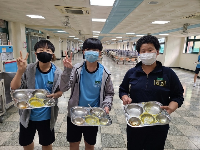  즐겁게 급식을 먹고 싹 비운 식판을 내보이는 영성중 학생들. (사진=영성중학교 제공)