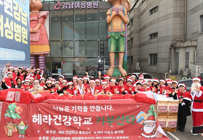10일 수원 강남여성병원 앞에서 이재준 수원시장(앞줄 가운데)과 어울림헤라봉사회 관계자들이 산타 행사에 함께하고 있다.