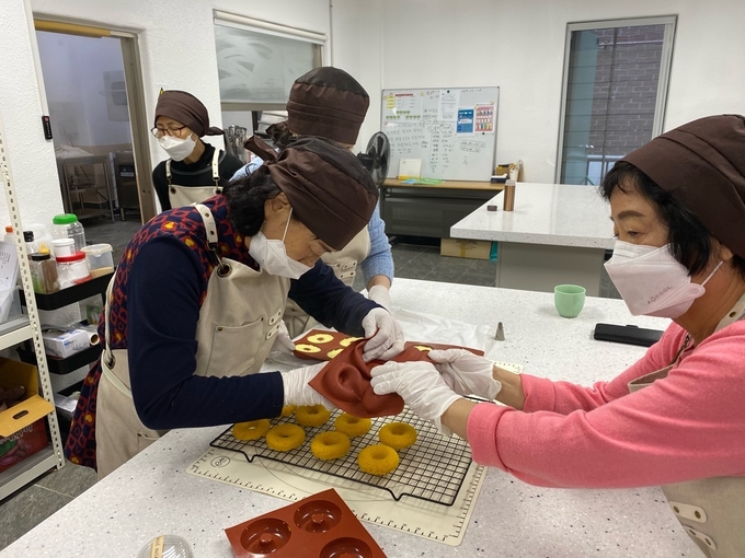 지난달 어울림 퓨전떡&디저트 사업에 참여한 노인들이 부평2동에 위치한 청춘공작소에서 빵을 만들고 있다. ( 사진 = 부평구 제공 )
