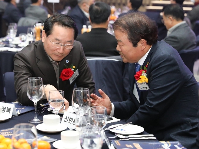 지난 8일 인천 송도컨벤시아에서 열린 인하대 동문회 송년행사에서 유정복 인천시장(왼쪽)과 신한용 인천시체육회장 후보가 대화하고 있다. 신 후보 측은 이 사진으로 카드뉴스를 만들에 배포했으나, 인천선관위는 배포 중지 조치했다. ( 사진 = 신한용 후보 제공 )