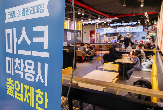  정부가 이달 말까지 실내 마스크 착용 의무를 조정하는 로드맵을 내놓을 예정인 가운데 11일 오후 인천국제공항 제2여객터미널의 한 매장에 마스크 착용 안내문이 세워져 있다. (사진=연합뉴스/자료사진)