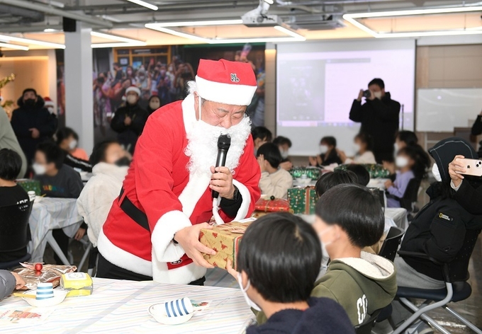 김경일 파주시장은 지난 17일 파주읍 연풍리 문화극장에서 열린 크리스마스 행사에 산타로 변신 아동시설(평화원) 아이들에게 선물을 주고 있다.(사진=파주시 제공)