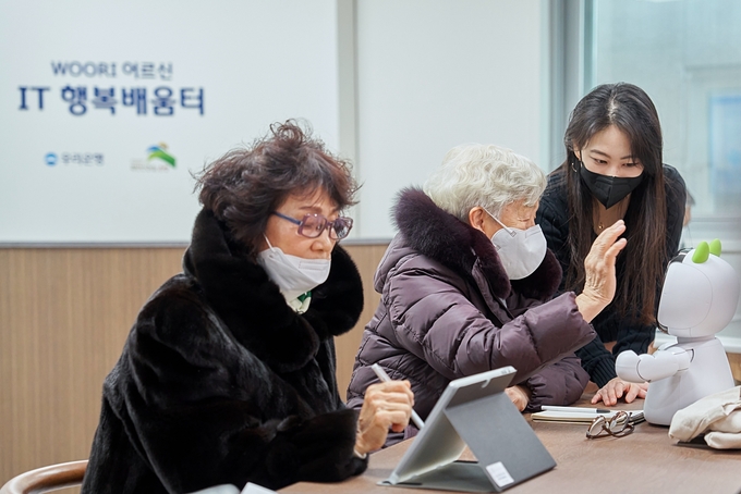 ‘WOORI 어르신 IT 행복배움터’ 에서 어르신들이 디지털 기기를 체험하고 있다. (사진=우리은행 제공)