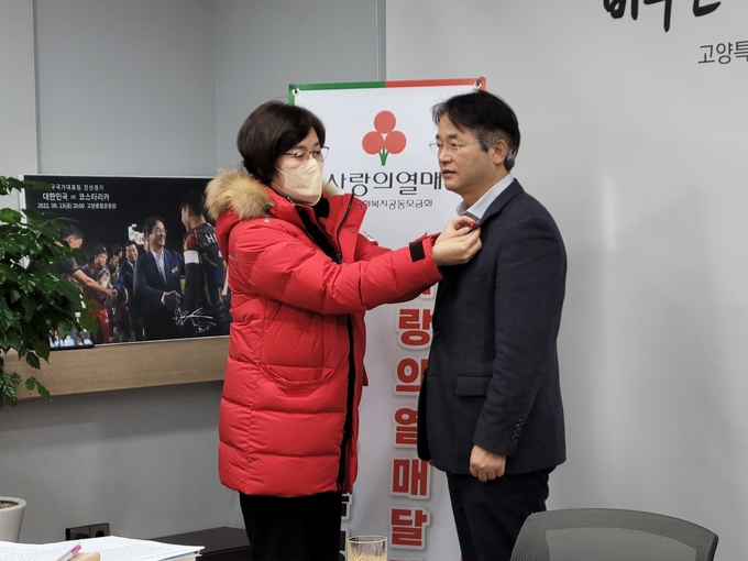 사랑의열매 이순선 회장이 이동환 고양시장에게 사랑의 열매를 달아주고 있다.(사진=고양시 제공)