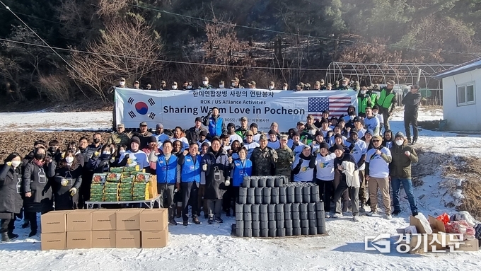 봉사활동에 나서기 전 나눔할 물품들을 앞에 두고 한미 양국 장병들이 기념촬영하고 있다. (사진=제5포병여단 제공)