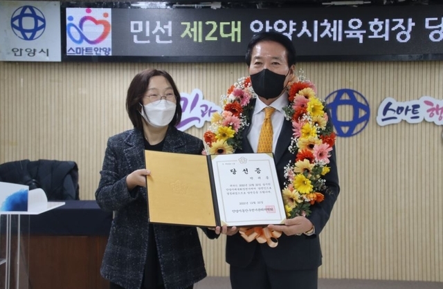 안양시체육회장 연임에 성공한 박귀종 회장(오른쪽)이 당선증을 받고 있다.(사진=안양시 제공)